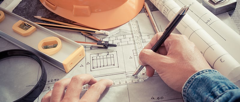 A Man Working on an Architectural Type of Drawing